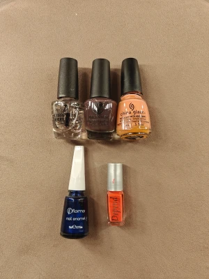 Fem nagellack i olika färger - Säljer fem nagellack i olika färger och märken. Färgerna är klar, brunlila, persikoorange, mörkblå med skimmer och neonorange. Märkena inkluderar W7, China Glaze, Flormar och Depend. Använda några gånger bara, nästan hela fulla