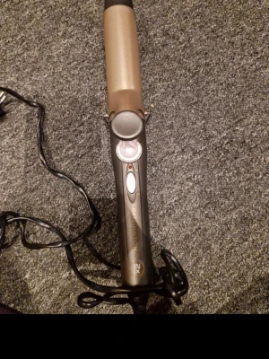 Remington Curling Iron - This is a Remington curling iron, as seen from the branding on the handle. It features a power switch (on/off) and a dial for temperature control. The '2X' marking likely refers to a feature such as double ceramic protection or double the styling power, which is common in Remington's product lines.