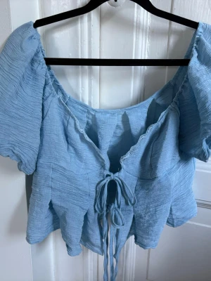 Ljusblå topp med knytning - Så gullig topp som man knyter fram till, jätte fint material o spets vid kanten. Köpt på Shein men aldrig använt. Köpt för 142kr🩵🩵🩵