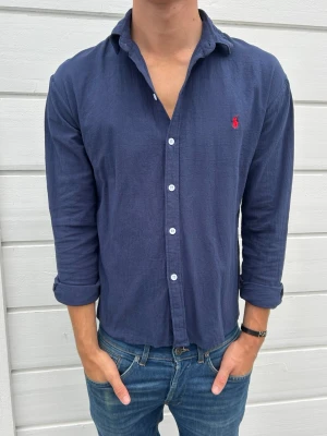 Ralph lauren linnskjorta - Säljer en riktigt snygg linneskjorta från Ralph Lauren i mycket fint skick. Den är endast använd ett fåtal gånger och har därför inga tecken på användning. Skjortan är tillverkad i ett tunt och luftigt linnematerial som passar perfekt under varmare dagar. Storleken är M, men den passar även dig som vanligtvis använder S beroende på önskad passform.  Hör gärna av dig om du har några frågor eller vill se fler bilder!