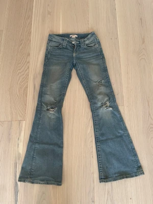 blå bootcut low waist jeans - säljer jättefina Gina tricot jeans med fint mönster på fickorna 😚