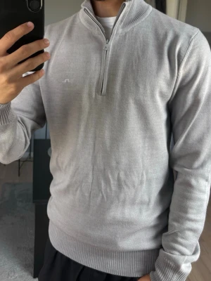 Ljusgrå J Lindeberg halvzip  - Ljusgrå halvzip i 100% merino, inga hål eller liknande. Hör av er vid ytterligare frågor!