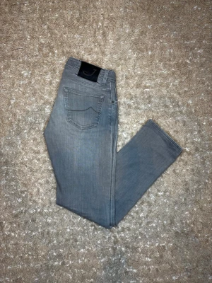 Jacob cohen jeans - Snygga grå jeans med rak passform och klassisk femficksdesign. Jeansen har en svart patch med ett J på bakfickan och är tillverkade i ett mjukt denimtyg. Perfekta för en avslappnad och stilren look. (6th photo shows small flaw). Old model 622. Authentic!