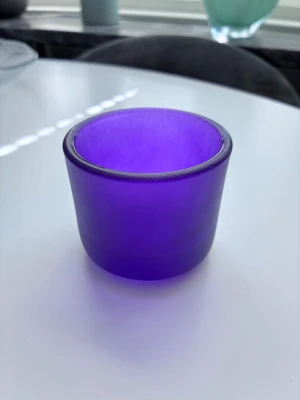 Lila glaslykta i frostat glas - En stilren lila glaslykta i frostat glas med rund form. Perfekt som ljushållare eller dekoration på bordet. Ger ett mysigt sken när ett värmeljus placeras i den. Passar bra i moderna och klassiska inredningar. 7cm diameter 6cm hög 