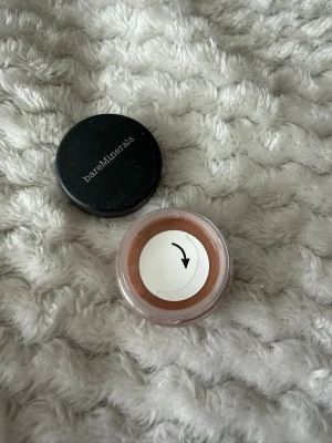 bareMinerals Warmth Bronzer - Säljer en bareMinerals Warmth bronzer i lös puderform. Färgen är varm brun med en naturlig finish som ger glow till ansiktet. Kommer i en rund plastburk med svart lock. Perfekt för att skapa solkysst look. Självklart oanvänd. Obs det är en liten modell i resestorlek. 