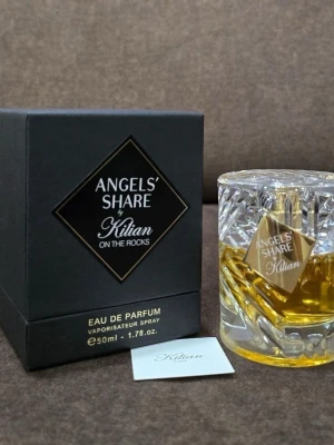 Kilian Angels' Share On The Rocks EdP - Lyxig parfym från Kilian, Angels' Share On The Rocks, i en elegant kristalliknande glasflaska med guldfärgad etikett. Flaskan rymmer 50 ml och doften är Eau de Parfum. Förpackningen är svart med gulddetaljer och har en exklusiv känsla.