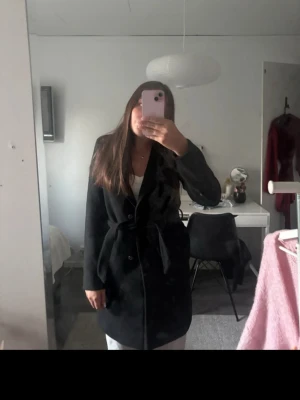 Svart kappa med knyte  - Säljer denna snygga svarta kappa ifrån hm i storlek S, perfekt nu till hösten.