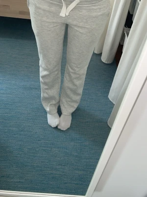 Ljusgrå mjukisbyxor med snörning - Säljer ett par ljusgrå mjukisbyxor med snörning i midjan. Byxorna har en relaxed passform och är perfekta för chill dagar hemma eller när du vill vara bekväm. Tillverkade i mjukt bomullsmaterial för extra komfort.