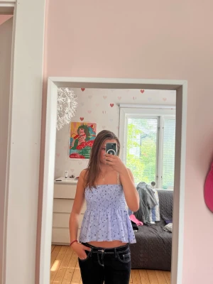Ljusblå blommig kjol/topp - Supersöt ljusblå kjol med smock och volang. Har använt någon gång som kjol och någon gång som topp men sparsamt använd. Färgen syns bäst på första bilden! Mkt stretchig i strl XS så passar även S🤗