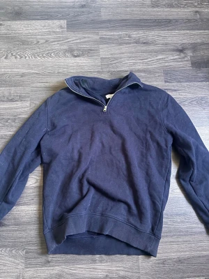 Mörkblå halfzip från These Glory Days - Mörkblå tröja med halv dragkedja från These Glory Days. Klassisk modell med ribbade muddar och krage som kan bäras uppvikt eller nedvikt. Perfekt till jeans eller chinos för en clean look.