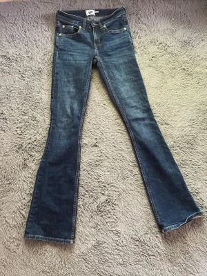 Mörkblå bootcut jeans - Säljer ett par mörkblå bootcut jeans med klassisk femficksdesign och snygga kontrastsömmar. Jeansen är varken högmidjade eller lågmidjade och är tillverkade i ett mjukt denimtyg som sitter skönt. Perfekta för dig som gillar en tidlös och avslappnad stil. De är från lager 157 och säljer då de inte används!☺️