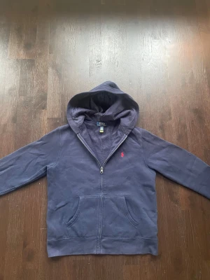Ralph lauren zip hoodie - En fin Ralph lauren hoodie med zip. Använd men fortfarande i mycket bra skick/ inga defekter! Det är storlek 14-16 och kostar ca 1200kr ny. Skriv vid frågor😊