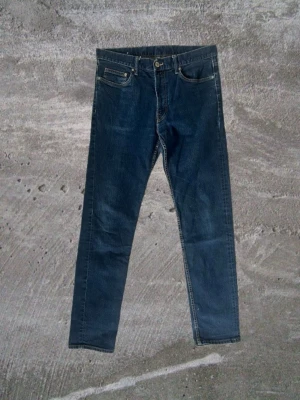 Mörkblå raka jeans - Snygga mörkblå jeans med rak passform och klassisk femficksdesign. Jeansen har kontrastsömmar och en enkel look som passar till det mesta. Tillverkade i bomull för en skön känsla. Längd 📏 : 103 cm Bredd: 41 cm