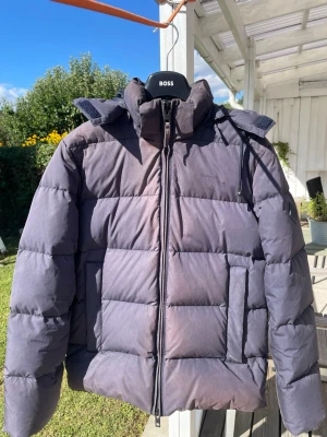 GANT marinblå Alta dunjacka S - GANT The Alta Down Jacket i storlek S. Varm marinblå dunjacka med avtagbar huva och diskret GANT-logga.  Dun- och fjäderfylld, vattenavvisande och ventilerande. Nypris för motsvarande Alta-modell låg runt 4 000 kr.  Bra begagnat skick. Mindre missfärgning/slitage vid kragen, se sista bilden. I övrigt fint skick utan större skador.  Säljes eftersom den inte används längre. Priset kan diskuteras vid snabb affär!