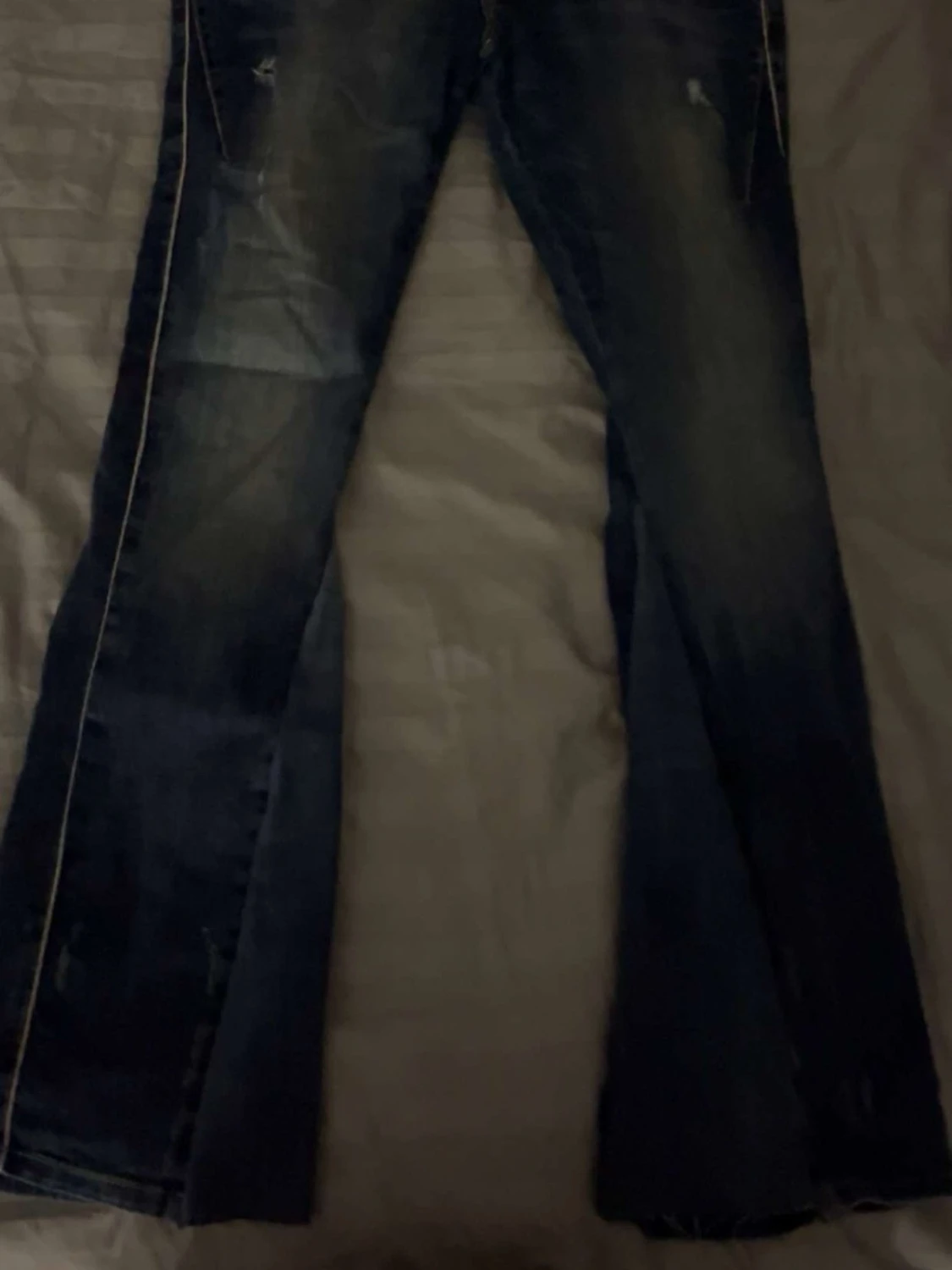 Mörkblå bootcut jeans med slitningar