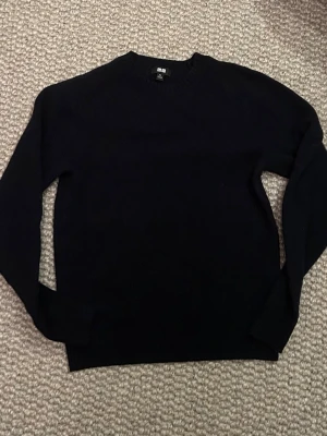 UNIQLO svart ulltröja – Herr XS - Stilren svart ulltröja från UNIQLO i toppskick. Enkel att matcha med jeans, chinos eller finare byxor och passar lika bra till vardags som till en mer uppklädd outfit.  Nypris 699 kr. Säljes för 499 kr, men är öppen för bud vid en smidig affär.