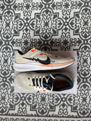 Nike Pegasus 40 Dragon Of The Year - Ett par nike pegasus 40 i bra skick, inga hål eller större slitage på dom. Storlek 44,5 men passar även 45. Sulan på både insidan och undersidan är hela och har inga större slitage, hälkragennör hel. Skickas samma dag vid köp! 