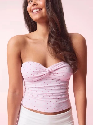 Ljusrosa prickig bandeau topp - Söt bandeau topp i ljusrosa med små rosa prickar och twistad detalj framtill. Toppen är croppad och axelbandslös, perfekt för varma dagar. Tillverkad i mjukt stretchigt material som sitter bekvämt mot kroppen.