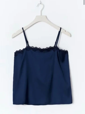 Mörkblått pyjamasset med spets - Sött tvådelat pyjamasset i mörkblått med linne och shorts. Linnet har tunna axelband och spetskant upptill, medan shortsen har elastisk midja och volangkant nedtill. Tillverkat i ett mjukt, glansigt material som är silke och känns skönt mot huden.💗