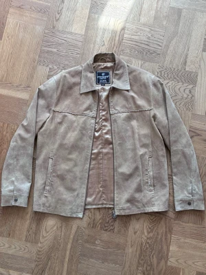 Beige skinnjacka - Beige skinnjacka från Petroff. Mått: Axelbredd 50 cm, ärmlängd 65 cm, längd 70 cm