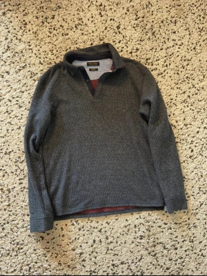 Mörkblå långärmad tröja Massimo Dutti - Snygg mörkblå långärmad tröja från Massimo Dutti i casual fit. Tröjan har en liten krage och knappar vid halsen samt diskret rutmönster i tyget. Perfekt för en avslappnad men stilren look. Står M, men passar S!!