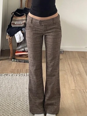 Bruna bootcut kostymbyxor  - Säljer dessa supersnygga low waisted bruna kostymbyxor med utsvängd passform och snygga knappdetaljer baktill. Hör av er för exakta mått. I mycket bra skick. ❤️🌸