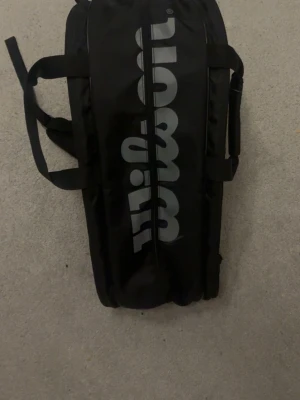 Padel väska - En Wilson padelväska med plats för 3 racket. Mycket rymlig och man får plats med allt man behöver. 