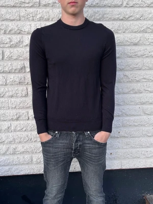 Marinblå långärmad tröja - En stilren svart långärmad tröja med rund halsringning. Tröjan har en smal passform och ribbade muddar vid ärmslut och nederkant. Perfekt att matcha med jeans för en enkel och clean look. Storlek XS