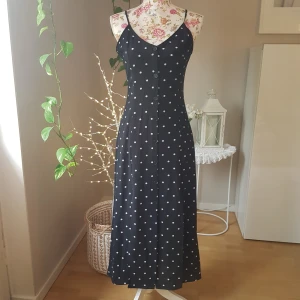 NY prickig klänning med knäppning - Ny med lappar kvar. Lite krinklad polyester. Helknäppning och dubbla slitsar framtill.