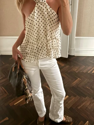 Vita raka jeans - Säljer ett par vita jeans med rak passform och normal midja. Jeansen har klassisk femficksdesign och stängs med dragkedja och knapp. Perfekta för en fräsch och stilren look.