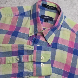 GANT Nantucket Linen Regular Fit skjorta rutig rosa/blå/grön storlek S - Rutig skjorta från GANT i Nantucket Linen Regular Fit. Färgstark men stilren kombination av rosa, blått och ljusgrönt som fungerar både casual och mer uppklätt. Tillverkad i bomull med inslag av linne för sval och lätt känsla.  Storlek S  Regular Fit  Fint skick.  Mått Bröstbredd: ca 50 cm Plagglängd: ca 76 cm Axelbredd: ca 42 cm Ärmlängd: ca 67 cm  Material 55% linne 45% bomull  Button down-krage, bröstficka och klassiskt rutigt mönster.