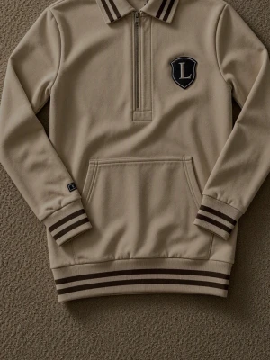 Limted edition Beige quarter zip hoodie Le Vichy - Stilren beige hoodie från Le Vichy med quarter zip, bröstpatch med L-logga och känguruficka. Krage och muddar har bruna ränder för en sportig look. Tillverkad i mjukt material, perfekt för en avslappnad men snygg outfit.