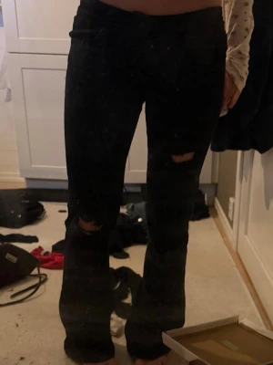 00 super low jeans - Säljer ett par as snygga svarta low waist bootcut jeans från Abrand. Använda några gånger men inga defekter mer än att de är påväg att bli slitna längst vid fötterna men inget man tänker på, nypris 999. Hålen är gjorda själva så inte helt perfekta 