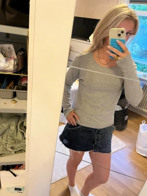 Ljusgrå långärmad topp 157 - En enkel och stilren ljusgrå långärmad topp från 157. Toppen har rund halsringning och är gjord i mjuk bomull, perfekt att matcha med jeans eller kjol för en clean look.