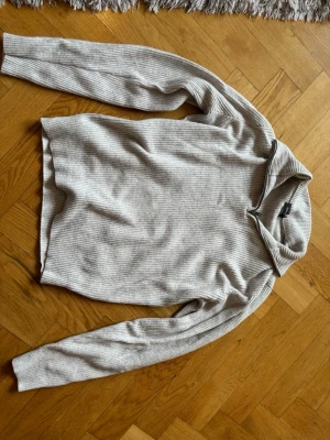 Beige stickad tröja med krage - Beige ribbad half-zip tröja från Dressmann i storlek S. Helt oanvänd och i nyskick! Stilren och bekväm modell som passar till det mesta. Nypris ca 700 kr.
