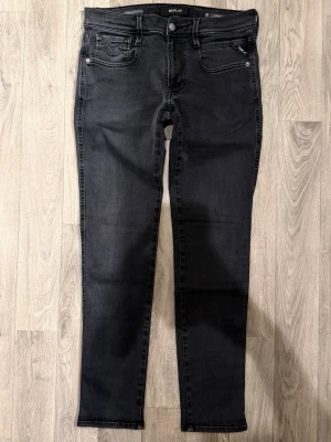 Replay Anbass Hyperflex Jeans Mörkgrå/Svart W31/L30 - Slim Fit - Replay Anbass Hyperflex mörkgrå/svarta jeans med slim fit-passform som sitter smalt och bekvämt och funkar till allt, storlek W31/L30, midja 40 cm, ytterbenslängd 98 cm, benöppning 15 cm, modellen är 185cm & väger 65kg, i fint skick.