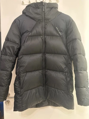 Svart vinterjacka  från Röhnisch - Snygg svart vinterjacka från Röhnisch med huva och dragkedja framtill. Jackan har en puffig design. Storlek S använd enstaka gånger 