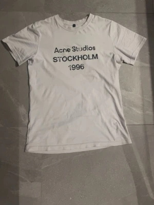 Vit Acne Studios t-shirt med tryck - Vit t-shirt från Acne Studios. Riktigt fräsch. Skriv vid någon typ av fråga eller fundering, priset kan diskuteras!🫱🏻‍🫲🏼