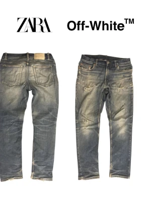 Blå slitna jeans med råa kanter - Säljer ett par blå jeans med slitningar och råa kanter nertill. Jeansen har fem fickor, normal midja och en tvättad look med ljusa partier. Perfekta för en avslappnad och trendig stil.