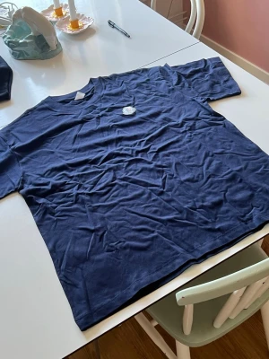Marinblå Moncler t-shirt - Snygg marinblå t-shirt från Moncler med klassisk rund hals och Moncler-logga på bröstet. T-shirten har korta ärmar och är tillverkad i mjuk bomull för en skön känsla. Perfekt till jeans eller shorts. Står XL men sitter som L!