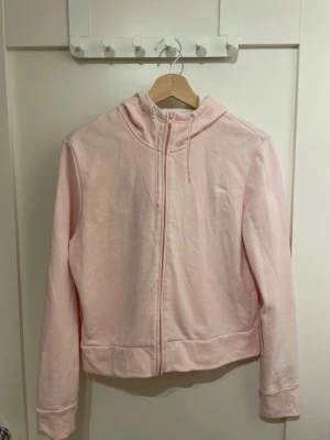 Ljusrosa Mexx zip up hoodie (strl. L) - Jättefin och superskön zip hoodie / munkjacka från Mexx i en perfekt ljusrosa färg. Modellen är aningen croppad (lite kortare i modellen) vilket ger en supersnygg passform till högmidjade jeans eller mjukisbyxor!Jackan har en stilren Mexx-logga broderad på bröstet och luvan är fodrad med vitt tyg på insidan vilket ger en fräsch kontrast. Jättefint skick!📦 Skickas spårbart via Plicks integrerade frakt. Köparen står för frakten.
