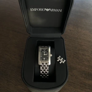 Klocka EMPORIO ARMANI - Stainless Steel klocka från EMPORIO ARMANI Behöver byta batteri Synliga repor Ink klocklåda och extra länkar.