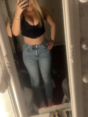 Ljusblå high waist skinny jeans, använt kanske en gång på fåtal timmar - Säljer ett par ljusblå high waist skinny jeans med klassisk femficksdesign och dragkedja med knapp. Jeansen har en tight passform och är perfekta till crop tops eller hoodies. Materialet är stretchigt denim som sitter snyggt och bekvämt.