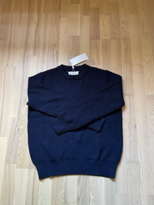 Mörkblå stickad tröja Maison Margiela - Maison Margiela stickad tröja mörkblå   Säljer en Maison Margiela stickad tröja i mycket bra skick perfekt nu för skolstart och fungerar till nästan allt🙌🏼  ✅ Använd endast ca 2-3  gånger ✅ Original tags kvar ✅ Mycket fint skick ✅  📩 Hör av dig vid intresse eller om du vill ha fler bilder/info.