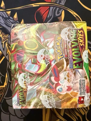 Pokémon Evolving Skies Booster Box - Säljer en Pokémon Sword & Shield Evolving Skies booster box. Boxen är färgglad med motiv av Rayquaza, Sylveon och Umbreon på framsidan och sidan. Perfekt för dig som samlar eller vill bygga din TCG-lek. 36pack booster box Evolving skies som låg i min källare, vill bli av med denna box den är lite skadad där uppe bland allt annat är allt i bra skick. Pris kan diskuteras!