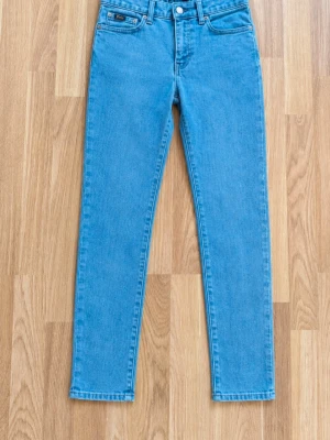 Polo Ralph Lauren jeans i snygg ljusblå tvätt 💙 - Klassiska jeans från Polo Ralph Lauren med fem fickor, raka/slimma ben och fina märkesdetaljer. Stor vit POLO-logo baktill i midjan samt Polo-detalj på myntfickan och originaletikett i midjan. Jeansen är i fint begagnat skick och passar perfekt till både vardag och en mer preppy/streetwear-inspirerad outfit. • Märke: Polo Ralph Lauren • Färg: Ljusblå denim • Modell: Rak/slim passform • Storlek: 12 år • Fint begagnat skick men har en fläck! Skriv gärna om du vill ha mått eller fler bilder! 🤍