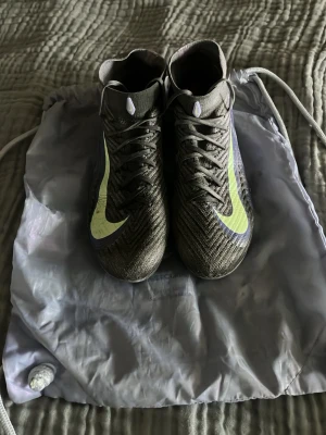 Grå Nike fotbollsskor med neonlogo - Säljer ett par lila Nike mercurial superfly. Skorna är ganska använda men kan definitivt användas mer. Skriv gärna och fråga vid funderingar och priset är inte hugget i sten och kan rabatteras vid fler köp av mina skor!