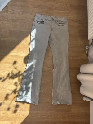 Ljusgrå bootcut jeans - Säljer ett par ljusgrå jeans med bootcut-modell. Jeansen har en liten blå färgfläck som inte vill gå bort. Går säkert bort med lite våld🫣😂. Men är ganska stretchiga. Det syns att dom är använda lite. Kan skicka mer bilder privat!