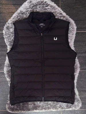 UBR Sonic Black Storm Väst  - Säljer en UBR Sonic Vest i färgen Black Storm, storlek M. Västen är använd men i mycket fint skick och har mycket kvar att ge. Nypris är 3 999 kr. En stilren och lätt premiumväst som fungerar perfekt både till vardags och för ett mer uppklätt uttryck.  Perfekt om du letar efter ett lite schysstare plagg med hög kvalitet, låg vikt och tidlös design.  • UBR Sonic Vest • Färg: Black Storm • Storlek M • Nypris: 3 999 kr • Använd men i mycket fint skick • Lätt, bekväm och stilren • Lite schysstare pr