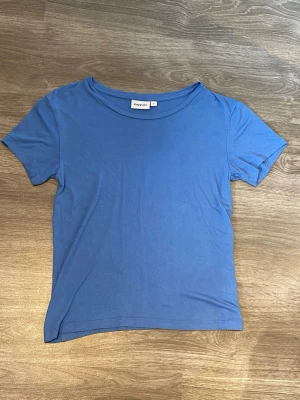 Blå basic t-shirt - En enkel blå t-shirt från Kappahl med rund halsringning och korta ärmar. Tillverkad i mjuk bomull som känns skön mot huden. Mjuk och luftig. 